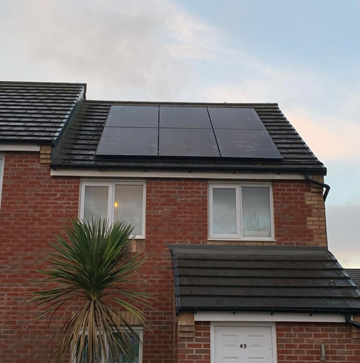 Solar panel installation on a red-brick semi-detached house with black-tile roof