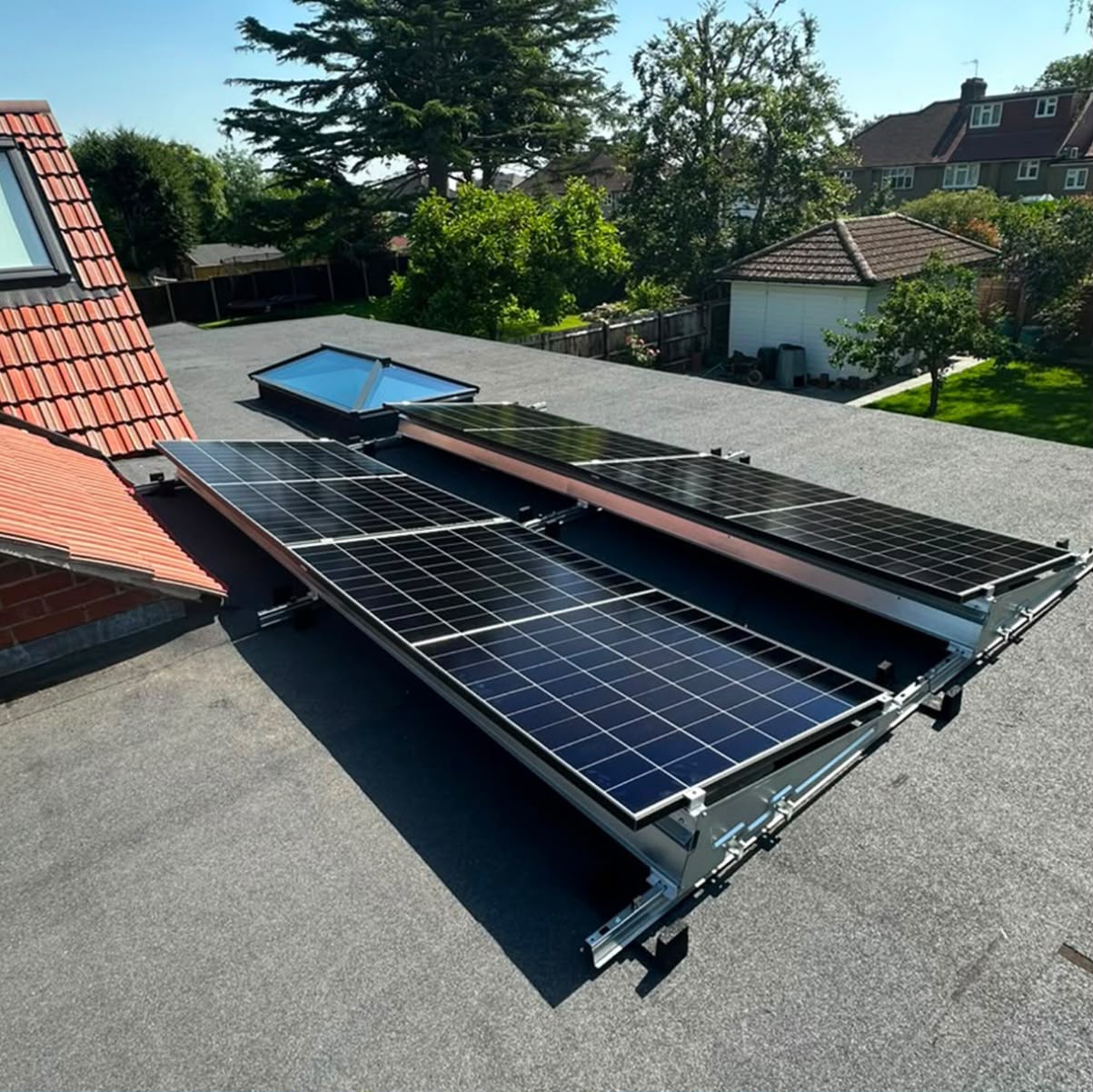 Tilted flat-roof solar panel array installed alongside a large rooflight