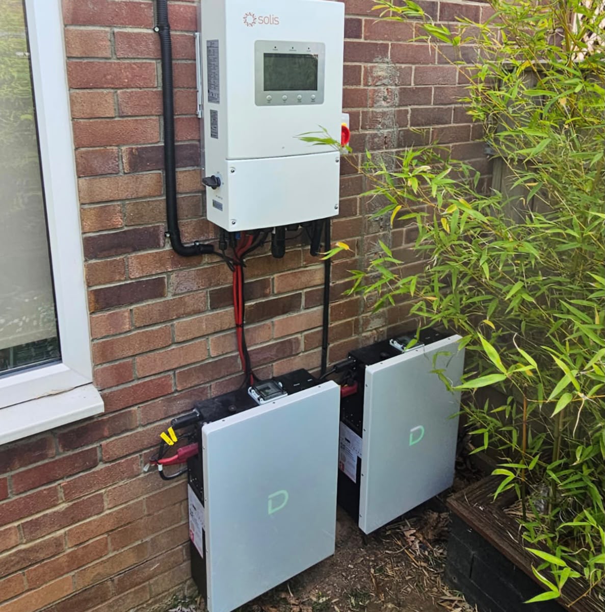Two-unit home battery storage system with Solis hybrid inverter installed outside a home